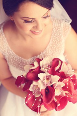 Beyaz ve kırmızı calla lily tutan güzel gelin