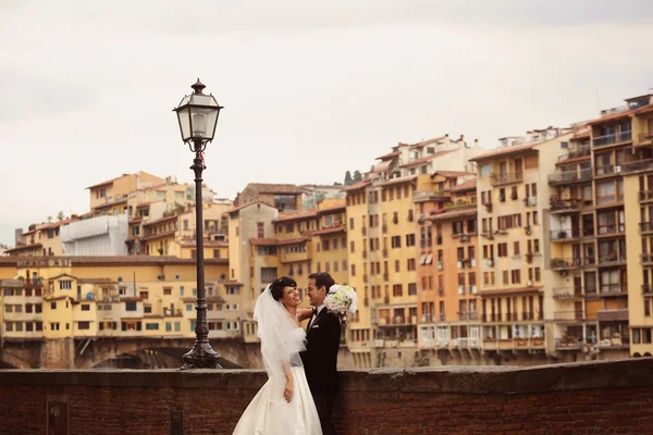 Bride and groom in the city laughing and hugging — Stock Photo, Image