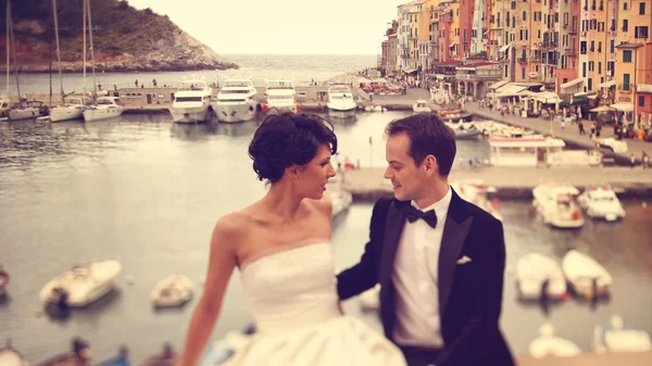 Bruid en bruidegom op brug met boten op achtergrond — Stockfoto