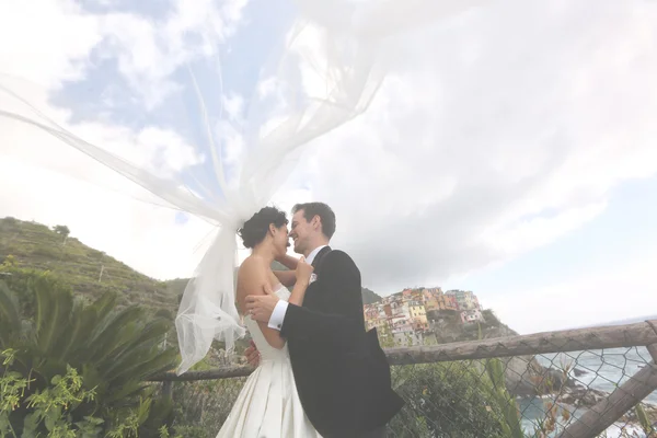 Happy bridal couple kissing near seaside — Stock Photo, Image