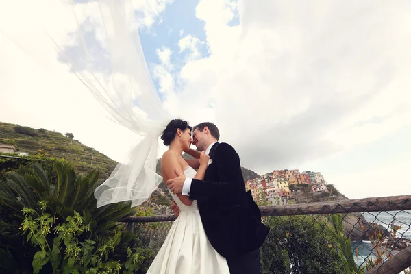 Happy bridal couple kissing near seaside — Stock Photo, Image