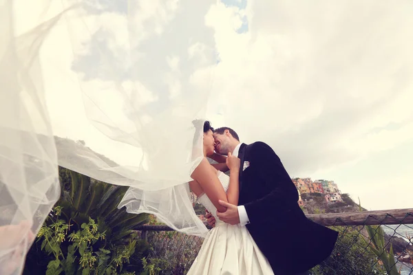Glückliches Brautpaar küsst sich am Meer — Stockfoto