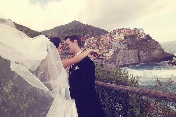 Happy bridal couple kissing near seaside — Stock Photo, Image