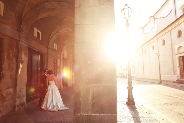 Bride and groom at sunset in old city — Stock Photo, Image