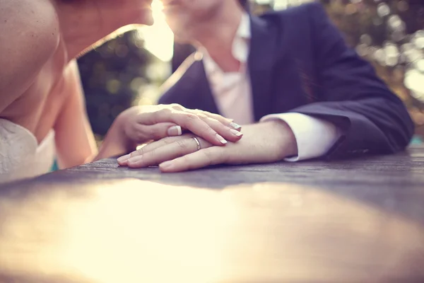 Κρατώντας τα χέρια με το γαμήλιο δαχτυλίδι στο φως του ήλιου — Φωτογραφία Αρχείου