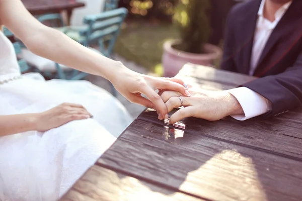 Tomando de la mano con anillo de bodas a la luz del sol —  Fotos de Stock