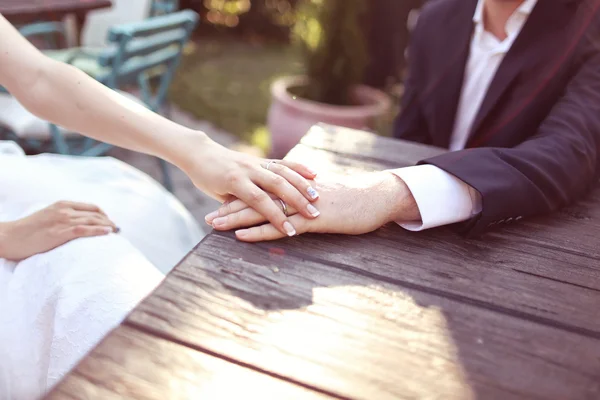 Tomando de la mano con anillo de bodas a la luz del sol —  Fotos de Stock