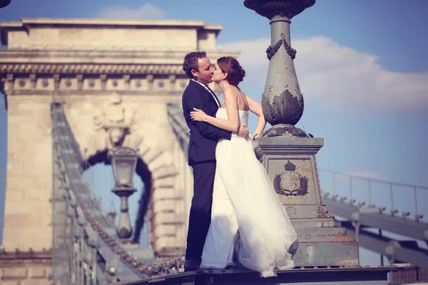 Mariée et marié s'amusent sur un pont — Photo