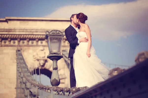 Braut und Bräutigam haben Spaß auf einer Brücke — Stockfoto