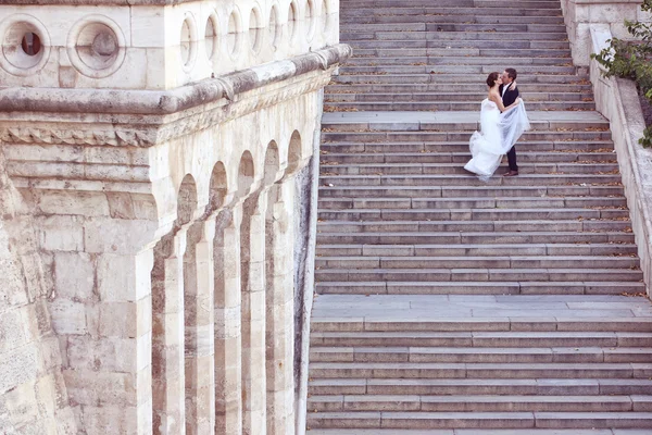 Noiva e noivo beijando nas escadas — Fotografia de Stock
