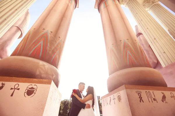 Bruden och brudgummen ha kul nära en stor byggnad — Stockfoto