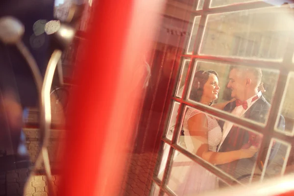 Nevěsta a ženich baví u telefonní budky — Stock fotografie