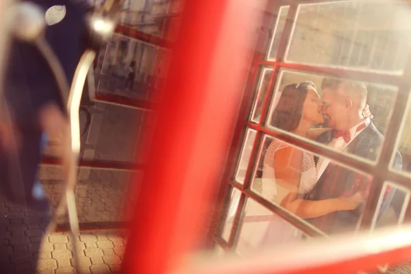 Novia y novio divirtiéndose cerca de phonebooth — Foto de Stock