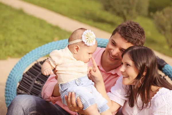 Pais sentados no parque com sua menina — Fotografia de Stock