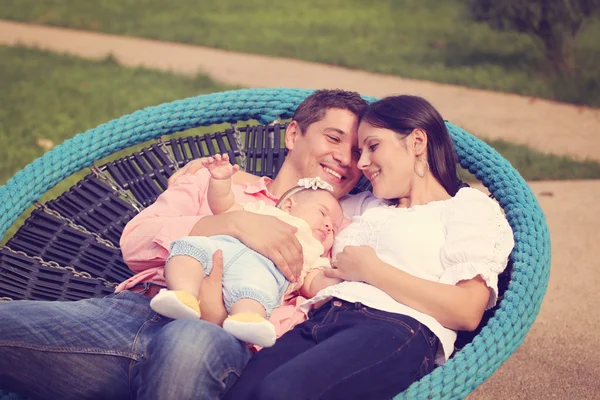Föräldrar som sitter i parken med sin flicka — Stockfoto