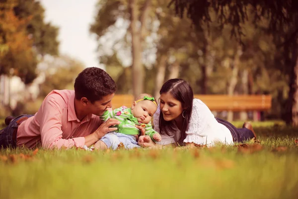 Eltern mit Baby auf Gras im Park — Stockfoto