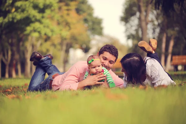 公園の芝生の上に座っている女の赤ちゃんを持つ親 — ストック写真