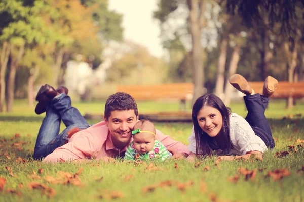 Rodzice z dzieckiem dziewczyna siedzi na trawie w parku — Zdjęcie stockowe