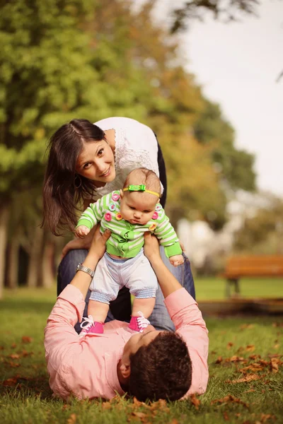 Parent lie down holding her baby girl up — Stock Photo, Image