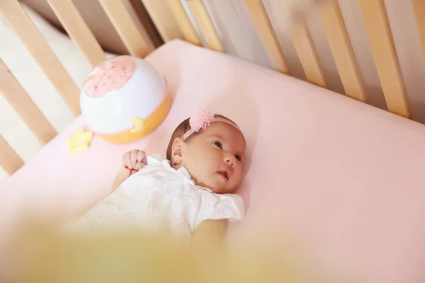 Beautiul meisje van de baby in haar bed — Stockfoto