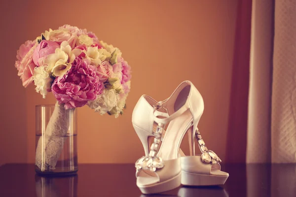 Elegant brudens skor med en bukett av pioner — Stockfoto