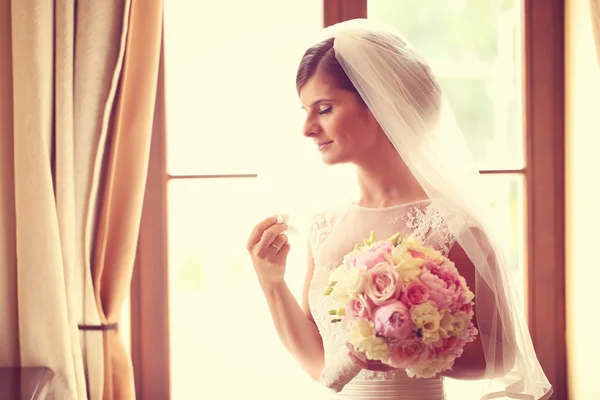 Noiva emocional em seu dia de casamento segurando buquê de peônias — Fotografia de Stock