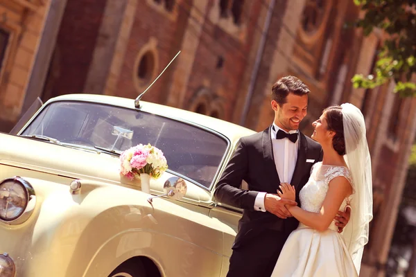 Bride and groom with a retro car — Stock Photo, Image
