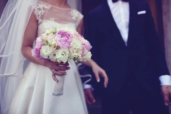 Bruid houden een mooie pioenrozen en rozen boeket — Stockfoto