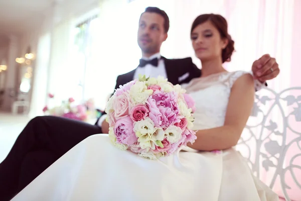 Bride and groom surrounded by flowers — Stock Photo, Image