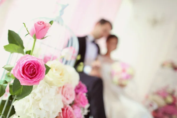 Bride and groom surrounded by flowers — Stock Photo, Image