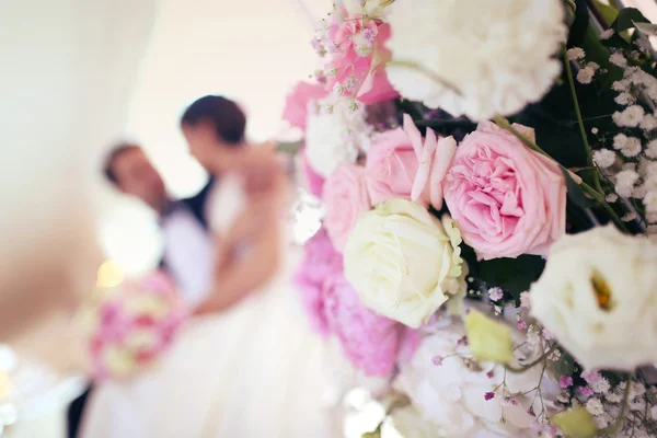 Bride and groom surrounded by flowers — Stock Photo, Image