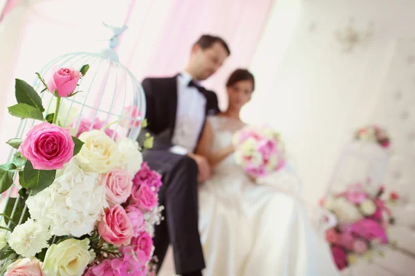 Bride and groom surrounded by flowers — Stock Photo, Image