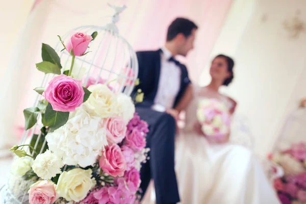 Bride and groom surrounded by flowers — Stock Photo, Image