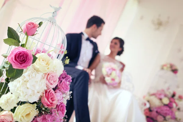 Bride and groom surrounded by flowers — Stock Photo, Image