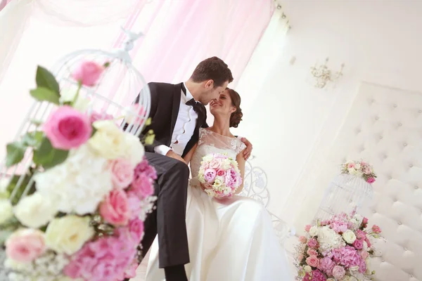 Bride and groom surrounded by flowers — Stock Photo, Image