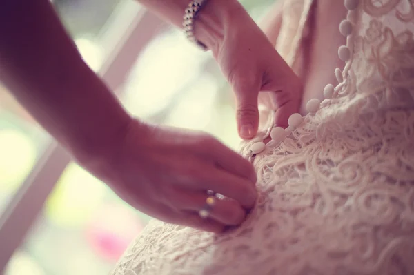Dama de honra ajudando a noiva com o vestido de noiva — Fotografia de Stock
