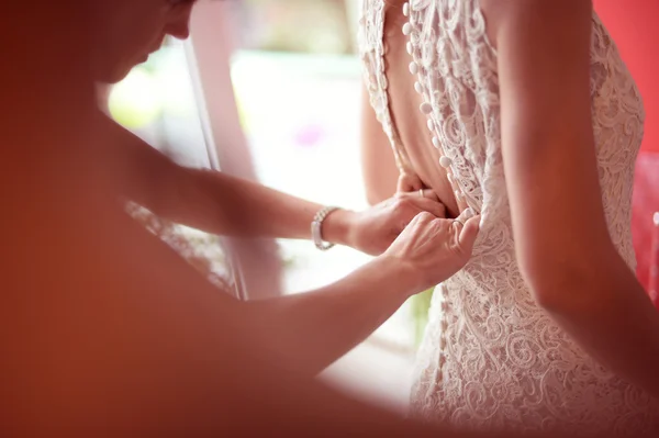 Dama de honor ayudando a la novia con el vestido de novia — Foto de Stock