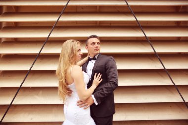 Gelin ve damat çizgili duvara poz