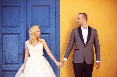 Gelin ve damat sarı duvar ve mavi kapı karşı