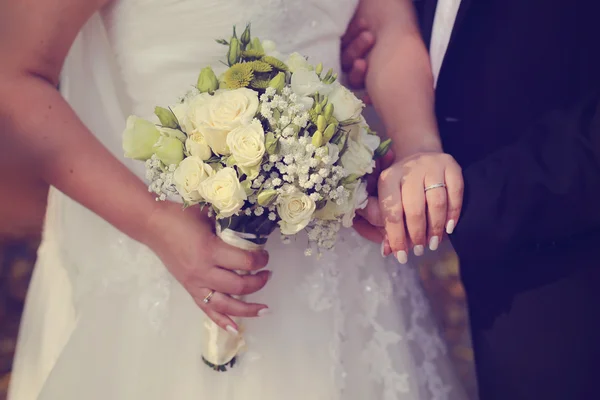 Mariée tient son bouquet de mariage avec son marié — Photo