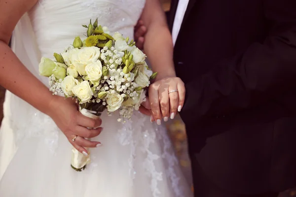 Mariée tient son bouquet de mariage avec son marié — Photo