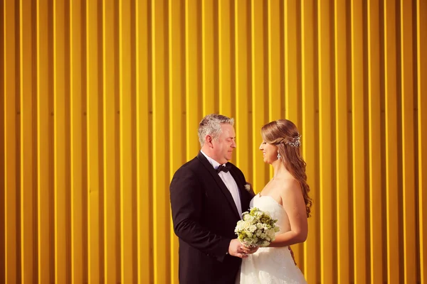 Наречений і наречений біля жовтої стіни — стокове фото