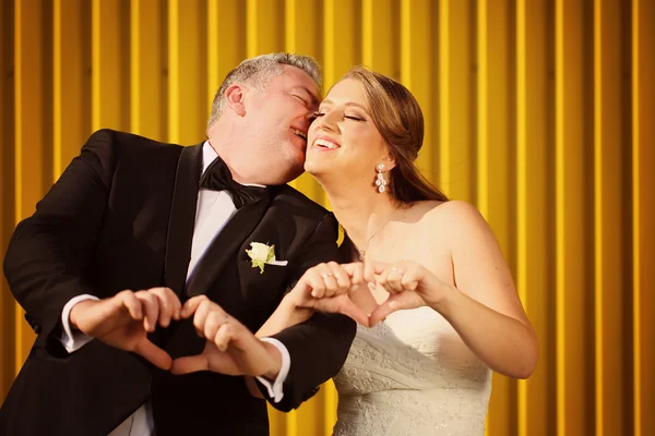 Nevěsta a ženich baví žluté zdi — Stock fotografie