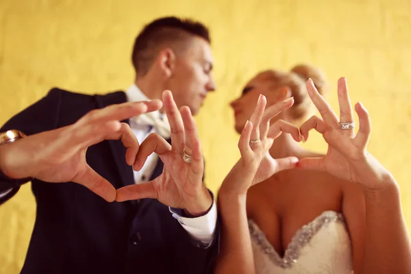 Bruide and groom making love sign with their hands — Stock Photo, Image