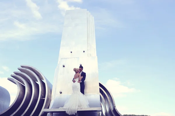 Brudparet sitter på arkitektoniska metalliskt bit — Stockfoto