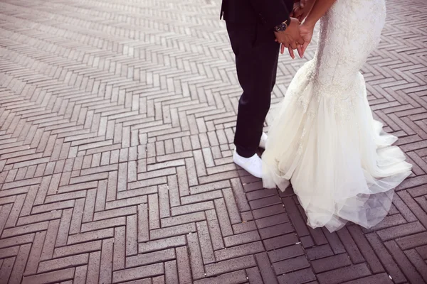 Mãos de uma noiva e noivo segurando — Fotografia de Stock