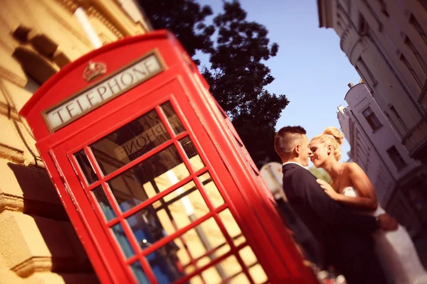 Bruden och brudgummen nära phonebooth — Stockfoto