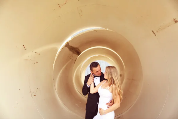 Bride and groom posing in a pipe — Stock Photo, Image