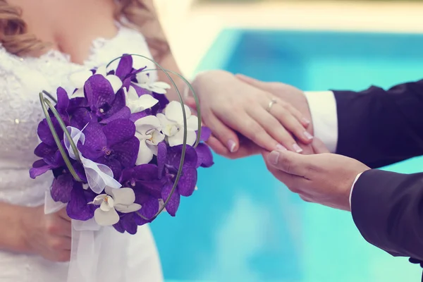 Mains de mariée et marié avec bouquet — Photo