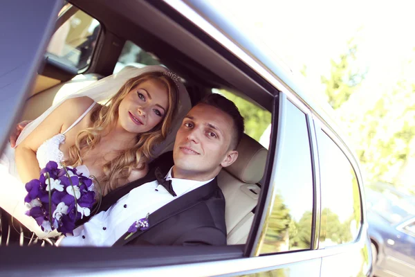 Noiva e noivo se divertindo no carro — Fotografia de Stock